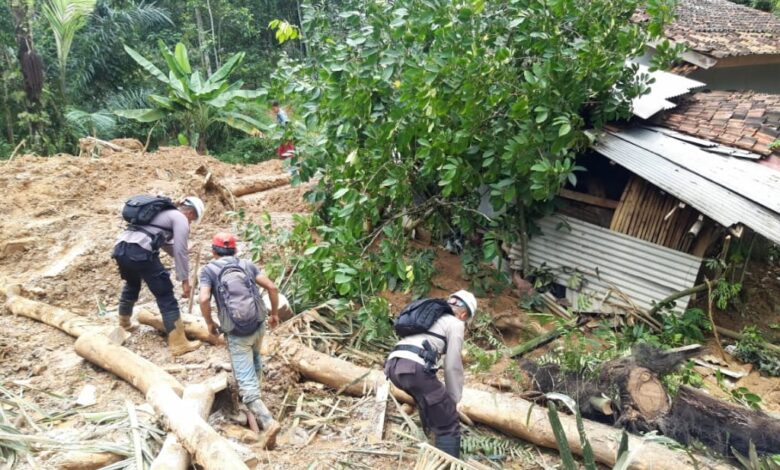 Anggota Brimob Kompi 4 Batalyon B Pelopor Cipanas membersihkan jalan tertutup longsor di Kampung Munjul, Desa Karangnunggal, Kecamatan Cibeber, Kabupaten Cianjur, Senin (23/03/2020).