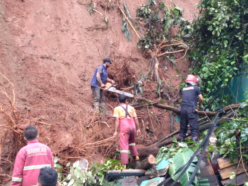 MEMBERSIHKAN: Petugas gabungan tengah membersihkan material longsor di Kampung Ciwareugu RT 02/RW 07, Desa Mekargalih, Kecamatan Cikalongkulon. (Foto: Rendi Irawan/cianjurupdate.com)