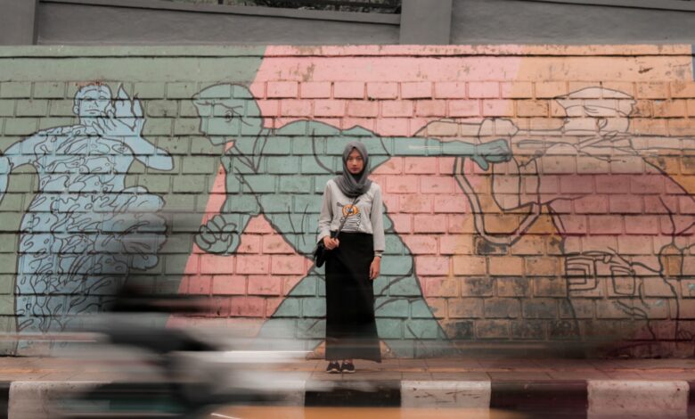 woman standing against mural wall