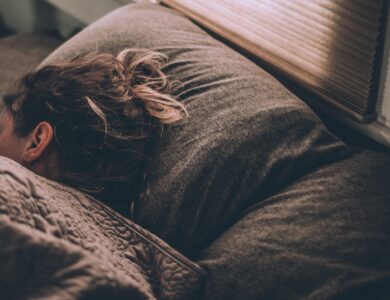 woman sleeping on bed under blankets
