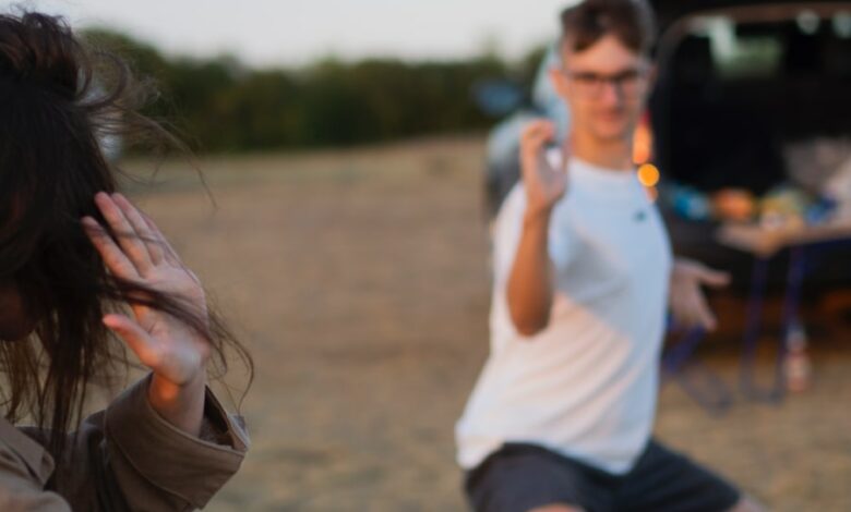 woman in white t-shirt and brown jacket holding smartphone