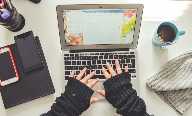 person in black long sleeve shirt using macbook pro