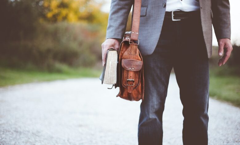 man holding book on road during daytime