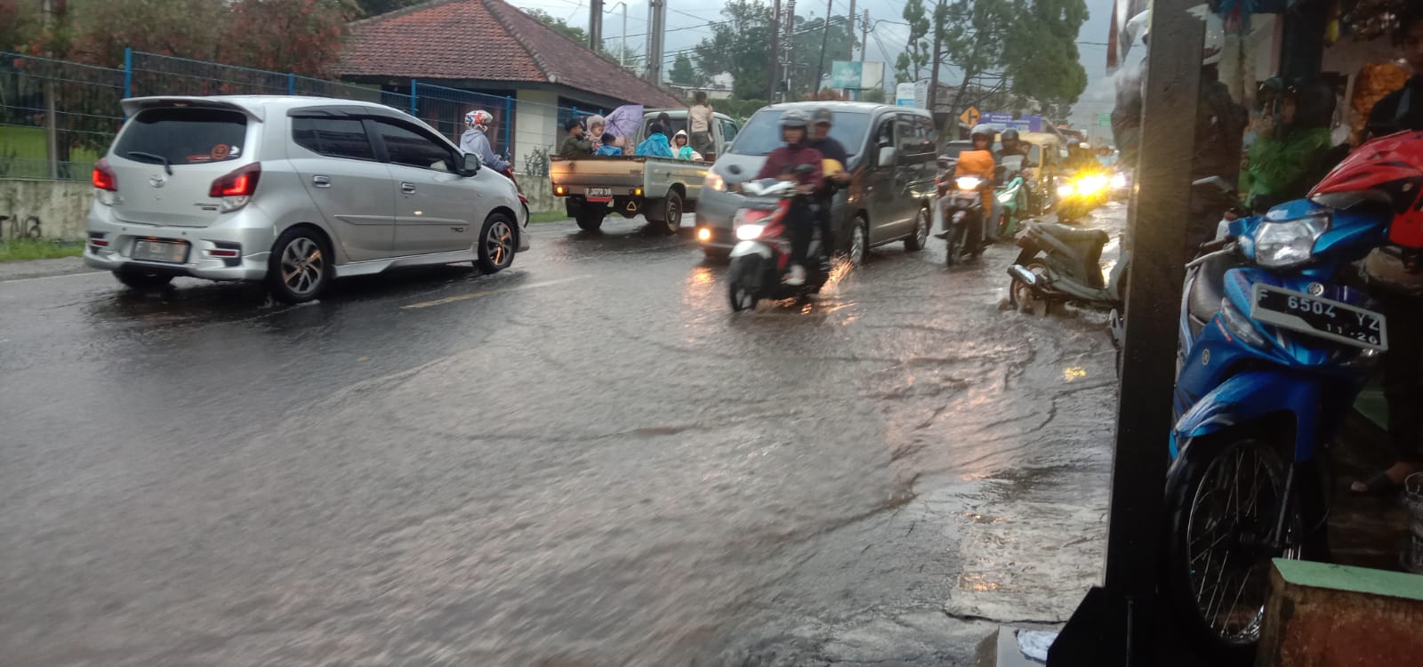 Banjir Luapan Drainase di Jalan Raya Cimacan Cipanas Cianjur Buat Kendaraan Sulit Melintas