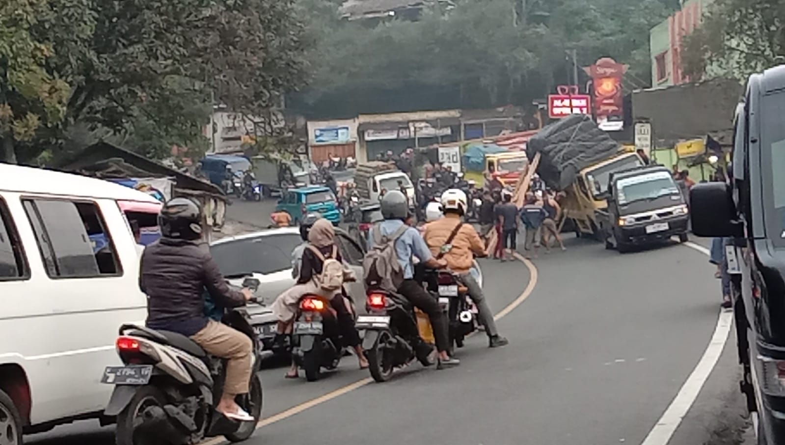 Truk bermuatan sayuran tiba-tiba miring dan nyaris terguling hingga mengakibatkan kemacetan di Jalur Puncak, Cianjur.