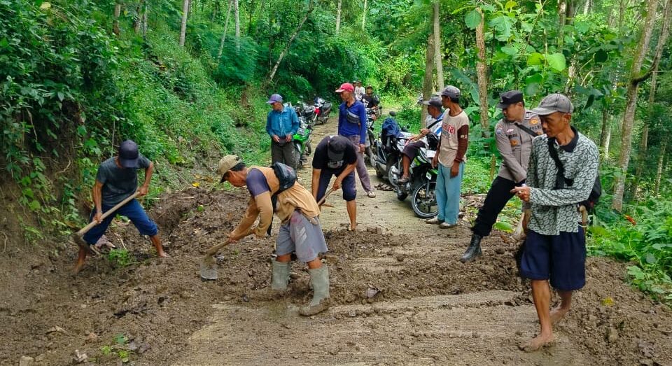 Bhabinkamtibmas Polsek Agrabinta, Brigpol Ayi Apendi, turun tangan langsung untuk menangani dampak longsor yang menutup jalan penghubung antar desa di Kecamatan Leles, Cianjur