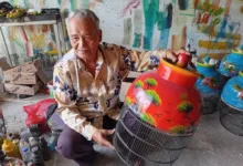 WARISAN KEAHLIAN: Didin Jaenudin, pengrajin di Desa Sindangasih, memperlihatkan sangkar burung lukis hasil karyanya. Keterampilan yang diwarisi sejak era 60-an ini terus bertahan dan menjadi penopang utama ekonomi warga setempat. (Foto: Fauzi/Cianjurupdate)