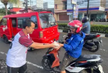 Manager PLN UP3 Cianjur menyerahkan paket sarapan gratis kepada salah seorang pengendara ojek sebagai bagian dari program "Berbagi Saling Menguatkan" di Cianjur.