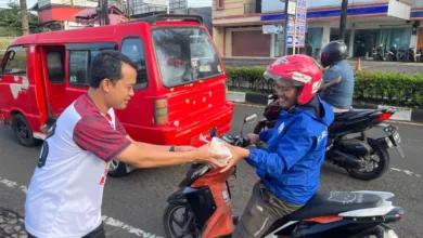 Manager PLN UP3 Cianjur menyerahkan paket sarapan gratis kepada salah seorang pengendara ojek sebagai bagian dari program "Berbagi Saling Menguatkan" di Cianjur.