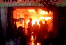 Api berkobar di Warung Nasi Ma Titing, Warujajar. Petugas dan warga terlihat di lokasi kejadian saat kebakaran terjadi pada malam hari.