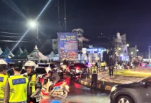 Petugas kepolisian mengatur arus lalu lintas di Bundaran Tugu Lampu Gentur, Cianjur, Rabu malam (31/12/2025), menyusul penutupan jalur menuju Puncak secara situasional menjelang pergantian Tahun Baru untuk mengurai kepadatan kendaraan.