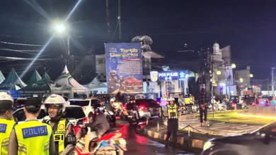 Petugas kepolisian mengatur arus lalu lintas di Bundaran Tugu Lampu Gentur, Cianjur, Rabu malam (31/12/2025), menyusul penutupan jalur menuju Puncak secara situasional menjelang pergantian Tahun Baru untuk mengurai kepadatan kendaraan.