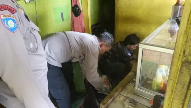 Seorang petugas kepolisian dari satuan Binmas melakukan pemeriksaan di sebuah kios