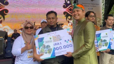 Bupati Cianjur (kanan) didampingi Kabid Pemasaran Pariwisata Disbudpar Cianjur, Tita Rosilawati (kiri), menyerahkan penghargaan secara simbolis kepada Yayan Sopyan (tengah) sebagai Juara 1 Sayembara City Branding Pariwisata Kabupaten Cianjur dalam acara Karnaval Lengkah Ka Jaman Anyar, Jumat (20/12/2025).