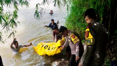 Personel Polsek Sindangbarang dibantu warga mengevakuasi jenazah Apid (64) dari Sungai Cisadea di Kampung Pasalakan, Desa Sirnagalih, Sindangbarang, Cianjur, Kamis (25/12/2025).