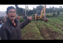 Tokoh masyarakat Pasir Cina Girang, Aryo Prima, menunjuk alat berat proyek geothermal yang masuk ke zona penolakan warga di Desa Cipendawa, Pacet, Minggu (11/1/2026).