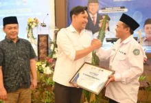 Bupati Cianjur, Mohammad Wahyu Ferdian (tengah) didampingi Kepala Disdikpora (kiri) berjabat tangan dengan Ketua DPD FK PKBM, Deni Abdul Kholik (kanan) usai membuka Bimtek Pendidikan Kesetaraan di Cipanas, Jumat (13/2/2026).